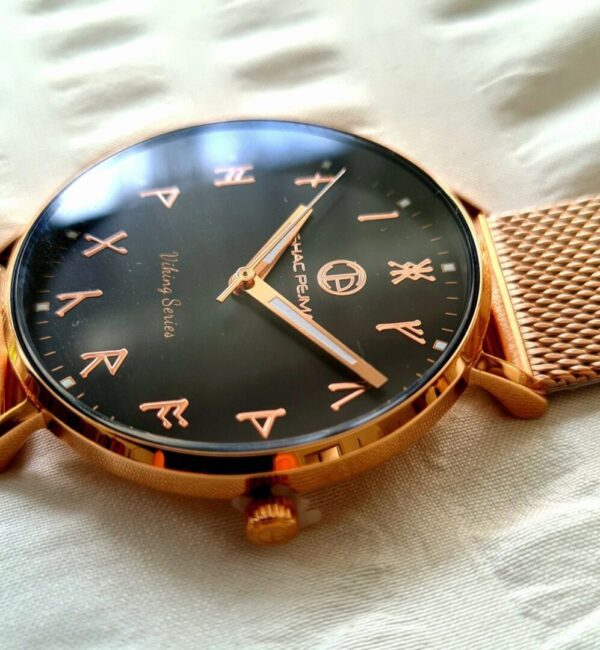 A gold watch with arabic numbers on it.