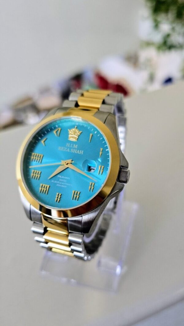 A blue and gold watch sitting on top of a table.