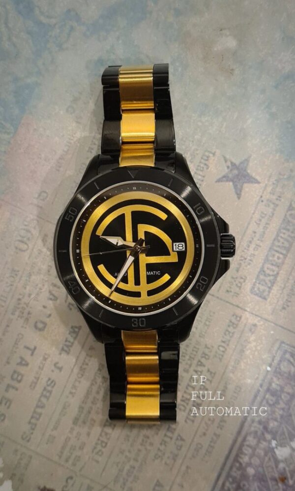 A black and yellow watch sitting on top of a table.