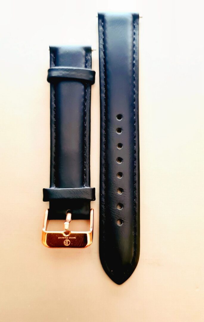 A black strap with gold buckle and a white background