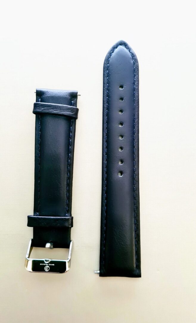 A black leather strap next to a white watch band.