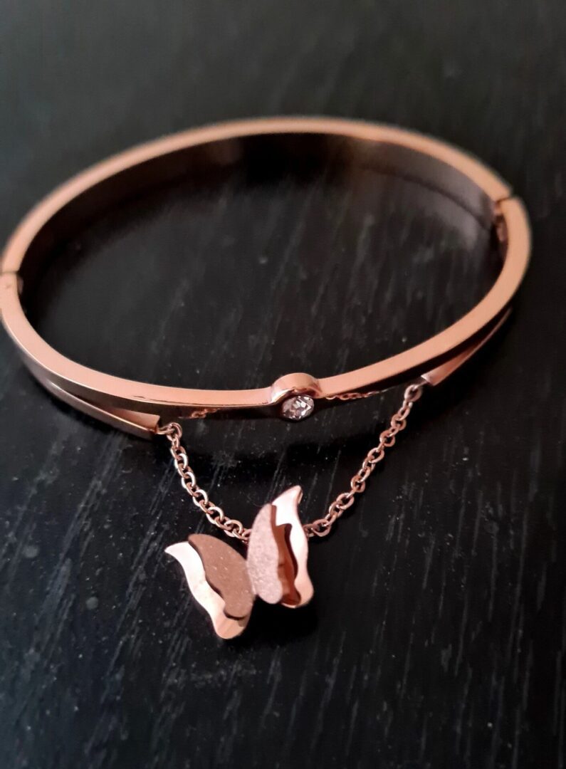 A bracelet with a butterfly charm hanging from it.