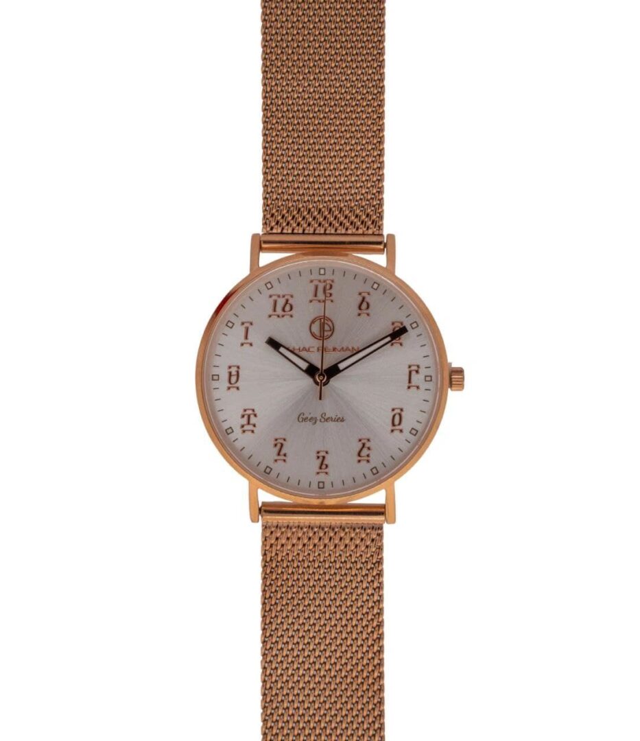 A rose gold watch with roman numerals on the face.