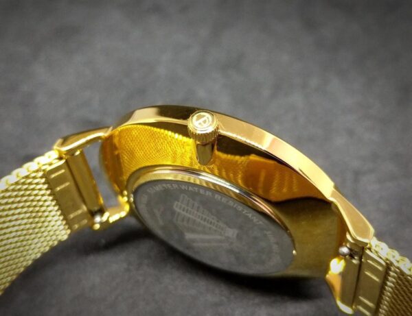 A gold watch with a black face and a silver band.