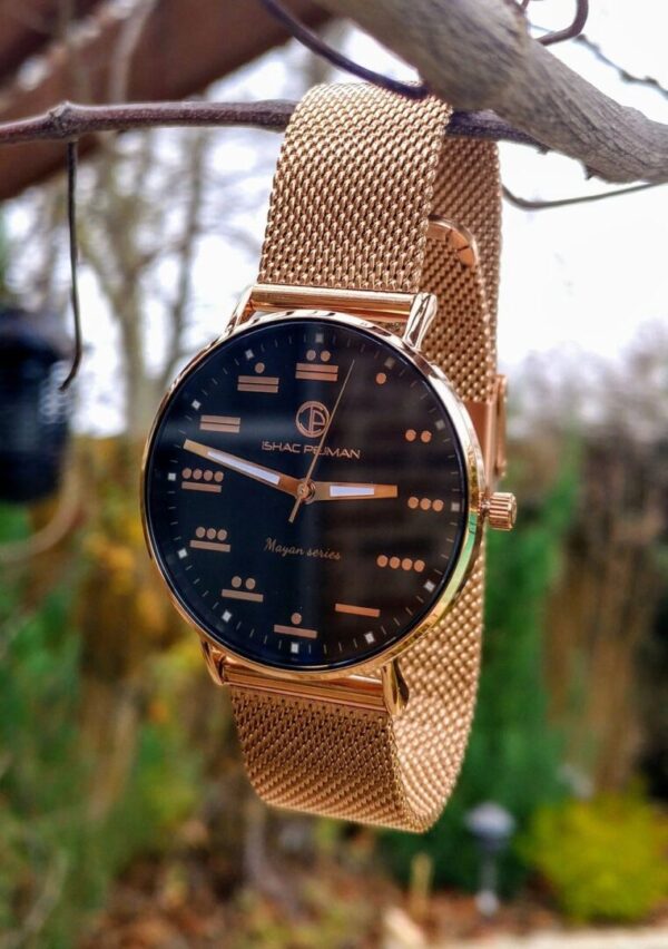 A watch hanging on the side of a metal fence.