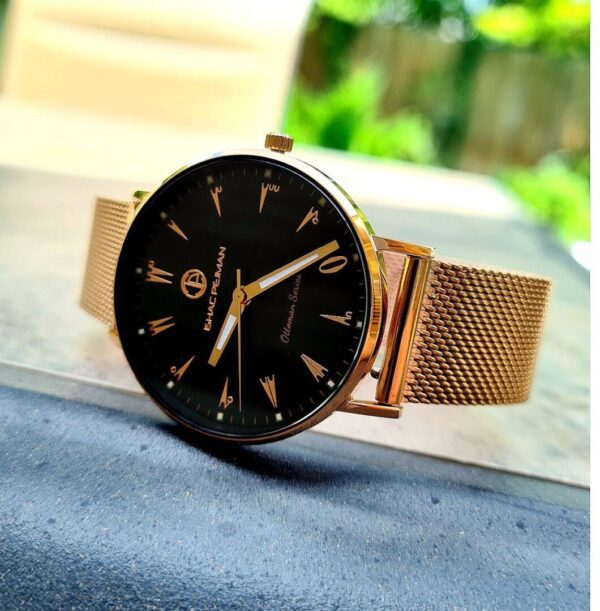 A gold watch sitting on top of a table.