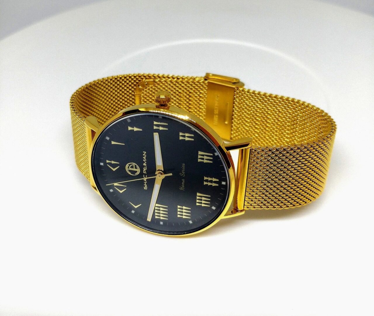 A gold watch with black face and mesh band.