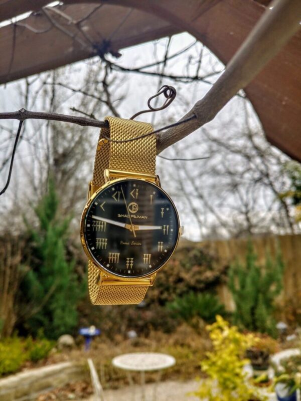A watch hanging from the side of a tree.