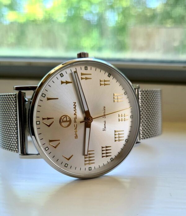 A silver watch sitting on top of a table.