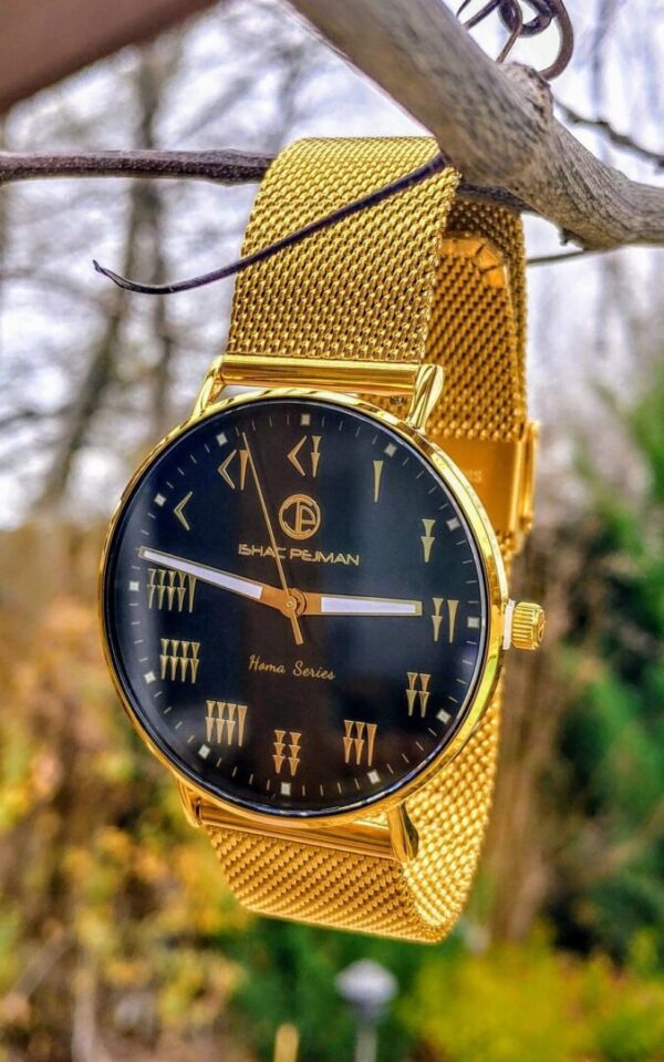A gold watch with roman numerals hanging on a tree branch.