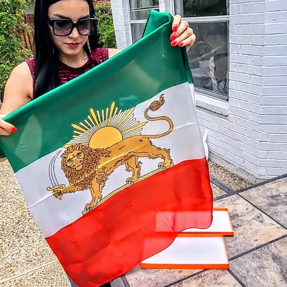 A woman holding up an italian flag outside.