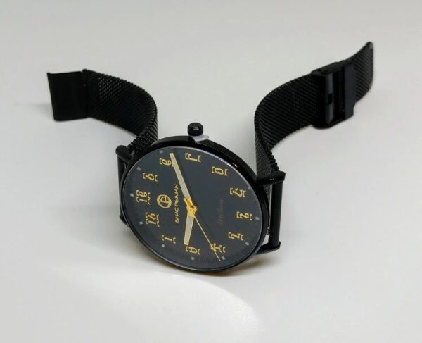 A black watch with yellow numbers on it.