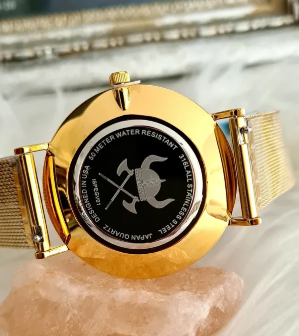 A gold watch with a black face and a rose quartz bracelet.